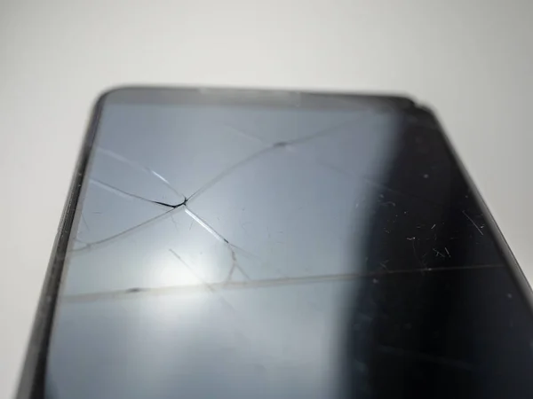 Old smartphone. Broken phone. Phone on a gray background. Broken smartphone.