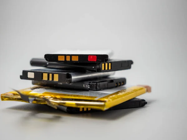 Old phone batteries. Replaceable batteries. Phone batteries. Batteries on a gray background. .