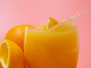 Orange and orange slice. Orange Juice Splashing. Orange on a pink background. Orange close up.