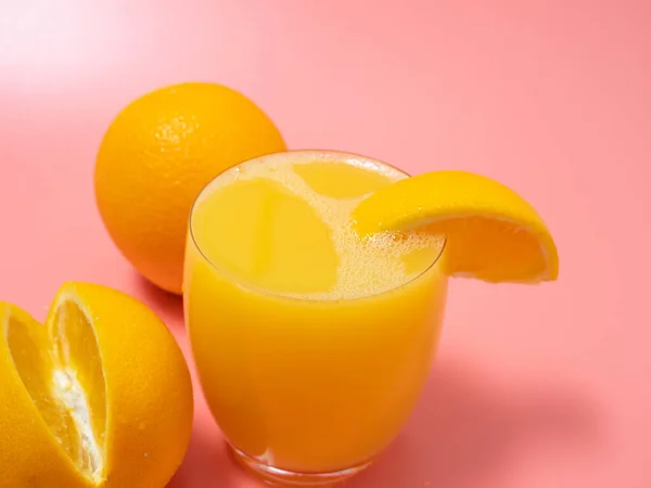 Orange and orange slice. Orange Juice Splashing. Orange on a pink background. Orange close up.