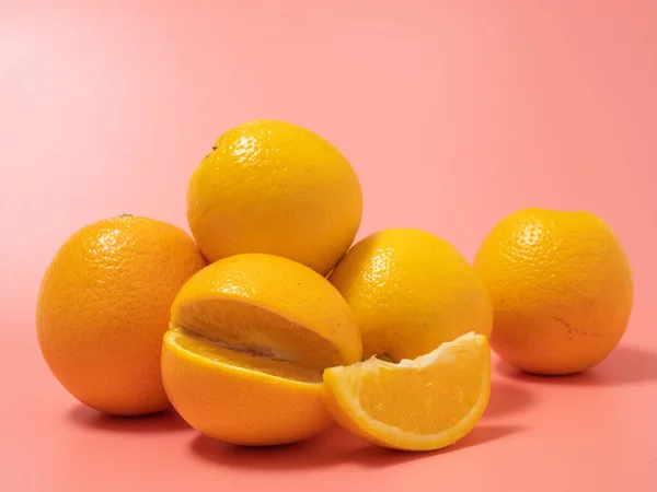 Orange and orange slice. Orange on a pink background. Orange close up.