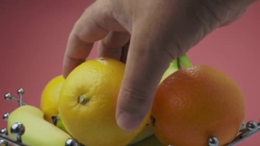 Putting fruits into a vase. metal bowl with fruit. High quality 4k footage