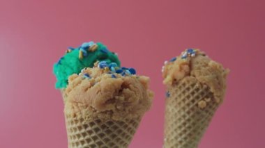 Turquoise blue and caramel ice cream on a pink background. High quality 4k footage
