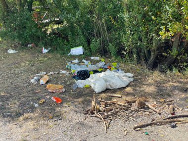 Littered park. Scattered trash. Littering garbage nature. Ecology.