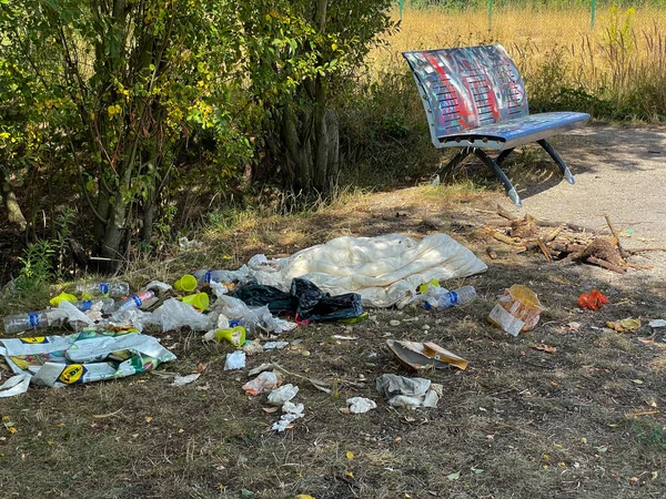 Littered park. Scattered trash. Littering garbage nature. Ecology.