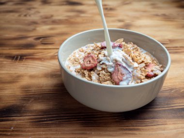 A cup with muesli and fresh berries on a wooden table. Healthy food, snack or breakfast. Healthy food.