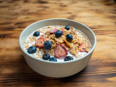 A cup with muesli and fresh berries on a wooden table. Healthy food, snack or breakfast. Healthy food.