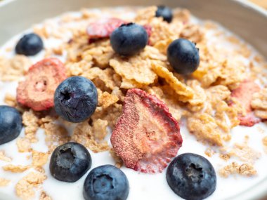 A cup with muesli and fresh berries on a wooden table. Healthy food, snack or breakfast. Healthy food.