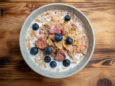 A cup with muesli and fresh berries on a wooden table. Healthy food, snack or breakfast. Healthy food.