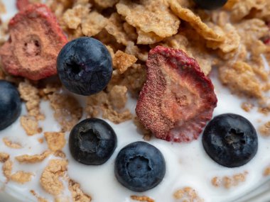 A cup with muesli and fresh berries on a wooden table. Healthy food, snack or breakfast. Healthy food.