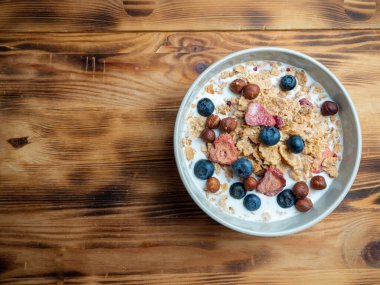 A cup with muesli and fresh berries on a wooden table. Healthy food, snack or breakfast. Healthy food.