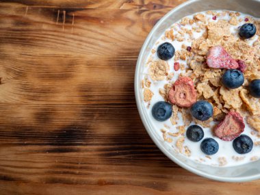A cup with muesli and fresh berries on a wooden table. Healthy food, snack or breakfast. Healthy food.