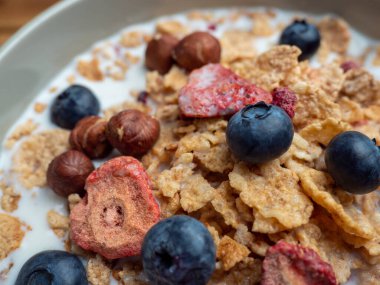A cup with muesli and fresh berries on a wooden table. Healthy food, snack or breakfast. Healthy food.