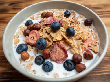 A cup with muesli and fresh berries on a wooden table. Healthy food, snack or breakfast. Healthy food.
