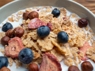 A cup with muesli and fresh berries on a wooden table. Healthy food, snack or breakfast. Healthy food.