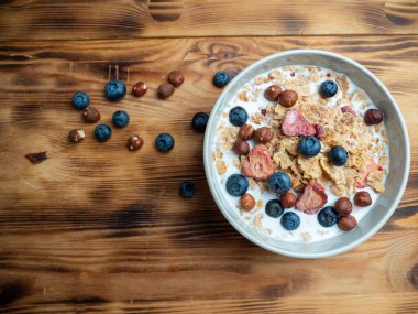 A cup with muesli and fresh berries on a wooden table. Healthy food, snack or breakfast. Healthy food.