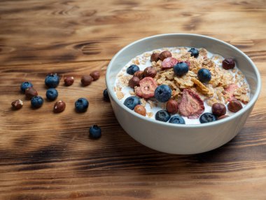 A cup with muesli and fresh berries on a wooden table. Healthy food, snack or breakfast. Healthy food.