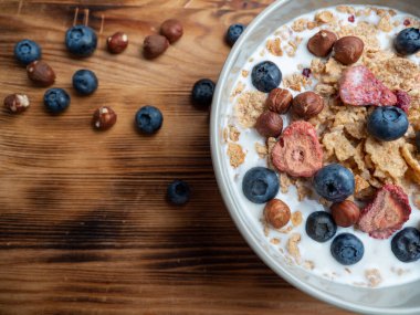 A cup with muesli and fresh berries on a wooden table. Healthy food, snack or breakfast. Healthy food.