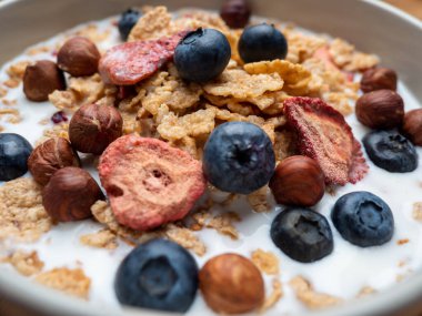 A cup with muesli and fresh berries on a wooden table. Healthy food, snack or breakfast. Healthy food.
