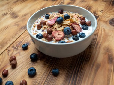 A cup with muesli and fresh berries on a wooden table. Healthy food, snack or breakfast. Healthy food.