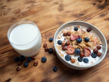 A cup with muesli and fresh berries on a wooden table. Healthy food, snack or breakfast. Healthy food.