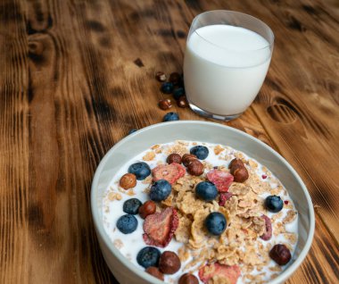 A cup with muesli and fresh berries on a wooden table. Healthy food, snack or breakfast. Healthy food.