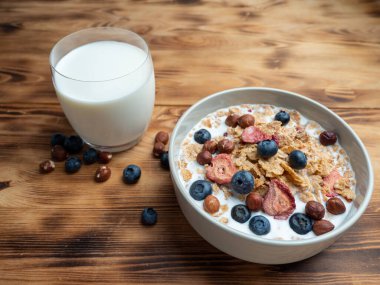A cup with muesli and fresh berries on a wooden table. Healthy food, snack or breakfast. Healthy food.