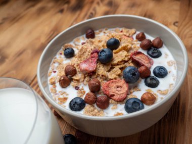 A cup with muesli and fresh berries on a wooden table. Healthy food, snack or breakfast. Healthy food.