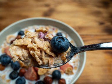 A cup with muesli and fresh berries on a wooden table. Healthy food, snack or breakfast. Healthy food.