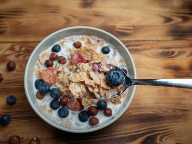 A cup with muesli and fresh berries on a wooden table. Healthy food, snack or breakfast. Healthy food.