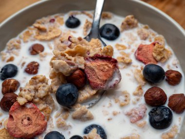 A cup with muesli and fresh berries on a wooden table. Healthy food, snack or breakfast. Healthy food.