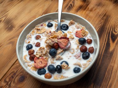 A cup with muesli and fresh berries on a wooden table. Healthy food, snack or breakfast. Healthy food.