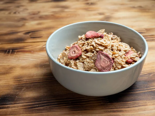 A cup with muesli and fresh berries on a wooden table. Healthy food, snack or breakfast. Healthy food.