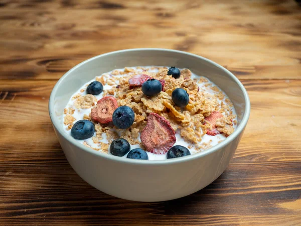 A cup with muesli and fresh berries on a wooden table. Healthy food, snack or breakfast. Healthy food.