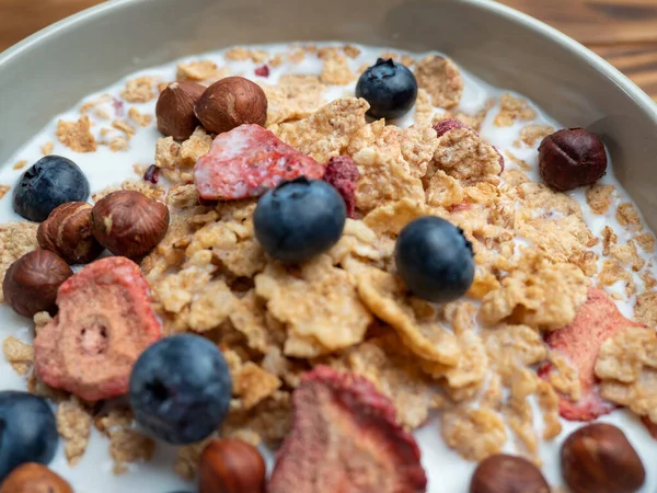 A cup with muesli and fresh berries on a wooden table. Healthy food, snack or breakfast. Healthy food.