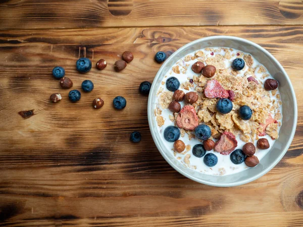A cup with muesli and fresh berries on a wooden table. Healthy food, snack or breakfast. Healthy food.