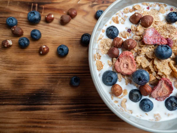 A cup with muesli and fresh berries on a wooden table. Healthy food, snack or breakfast. Healthy food.