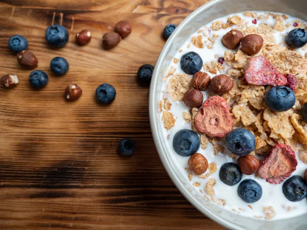 A cup with muesli and fresh berries on a wooden table. Healthy food, snack or breakfast. Healthy food.