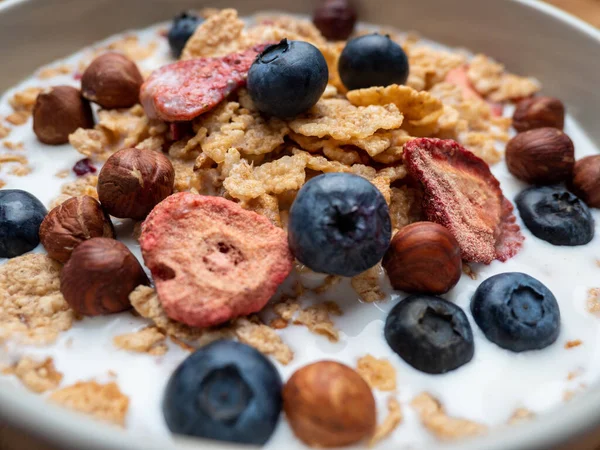 A cup with muesli and fresh berries on a wooden table. Healthy food, snack or breakfast. Healthy food.