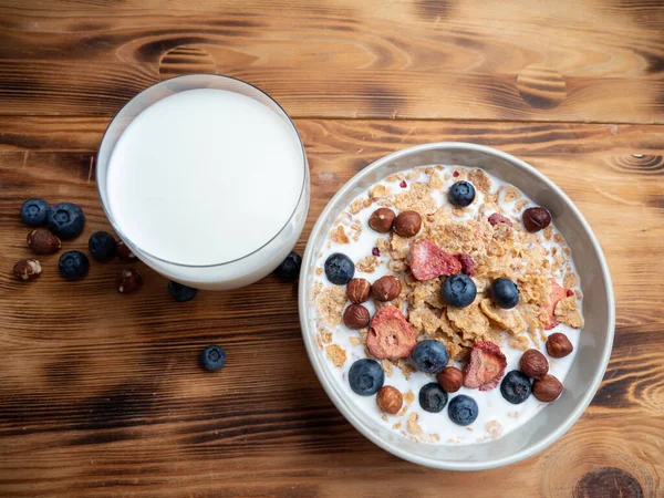 A cup with muesli and fresh berries on a wooden table. Healthy food, snack or breakfast. Healthy food.