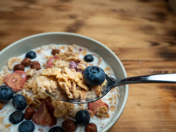 A cup with muesli and fresh berries on a wooden table. Healthy food, snack or breakfast. Healthy food.