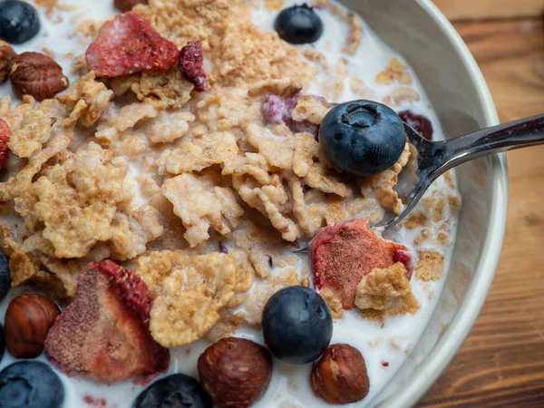A cup with muesli and fresh berries on a wooden table. Healthy food, snack or breakfast. Healthy food.