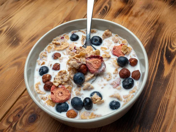 A cup with muesli and fresh berries on a wooden table. Healthy food, snack or breakfast. Healthy food.