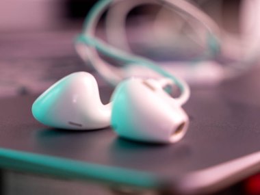 White headphones with a cable on a laptop. Close-up.