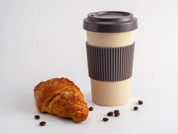 Croissant and a cup of coffee on a white background. Croissant and a cup of coffee close-up.