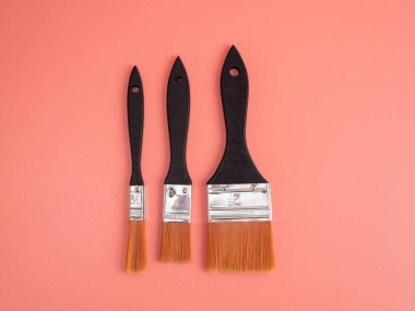 Brushes for painting on a pink background. Paint brushes. Close-up.