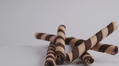 Chocolate wafer sticks or rolls, on a white background. Close-up. High quality 4k footage