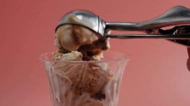 Close-up caramel ice cream is placed in a glass bowl with a metal spoon. High quality 4k footage
