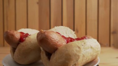 Boiled sausage with a bun on a wooden background. Bockwurst with a bun.