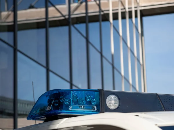 Blue light of a police car siren on a city street. Topics: crime, ambulance and assistance.